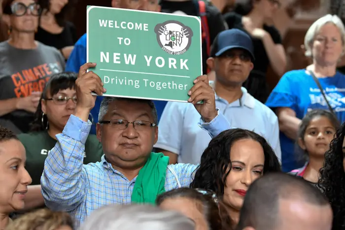 A protester holds a sign as members of the state Assembly speak in favor of legislation of the Green Light Bill, granting undocumented immigrant driver's licenses during a rally at the state Capitol in Albany in 2019.